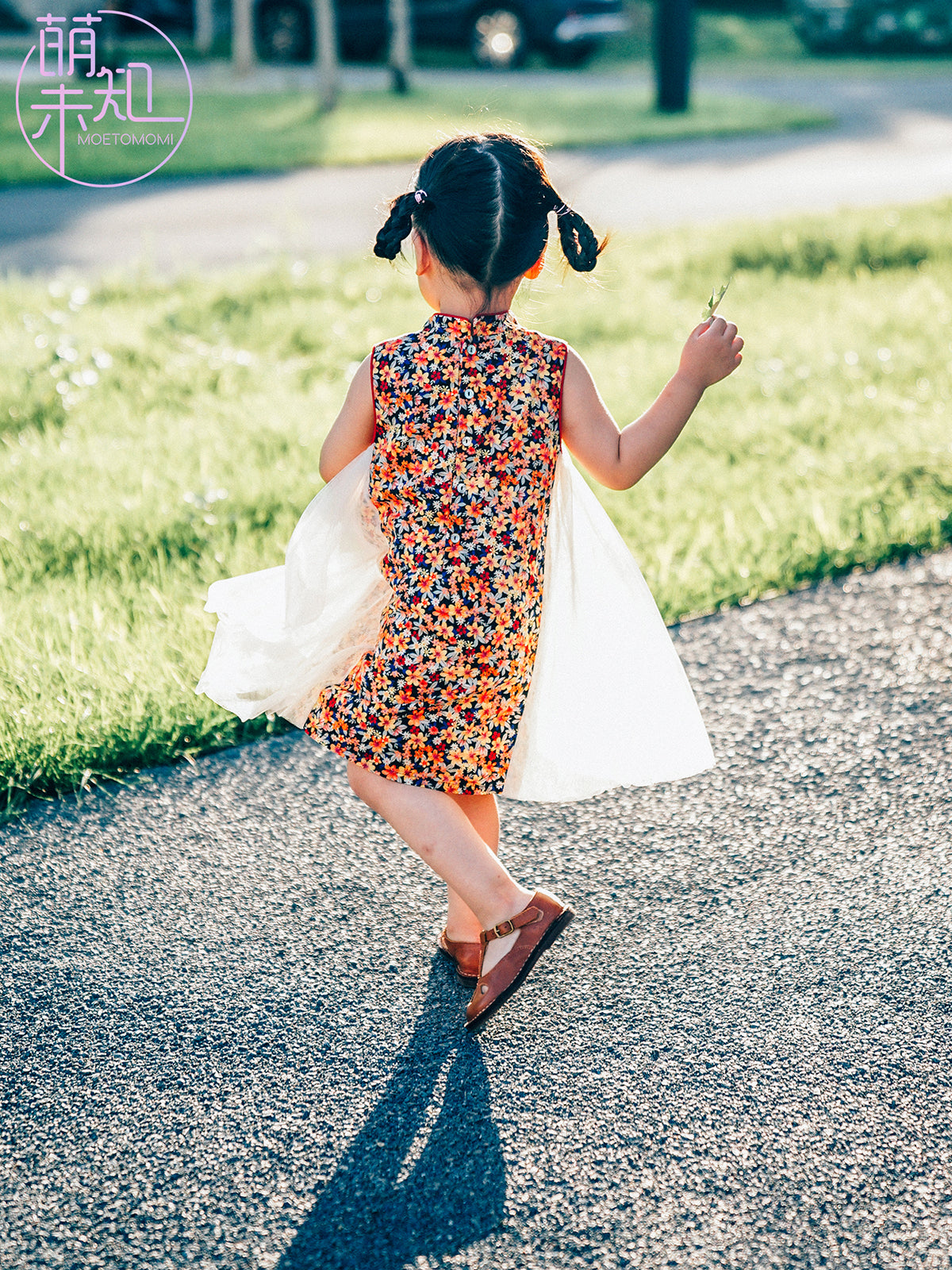 Girl wearing a floral qipao-inspired tulle dress outdoors