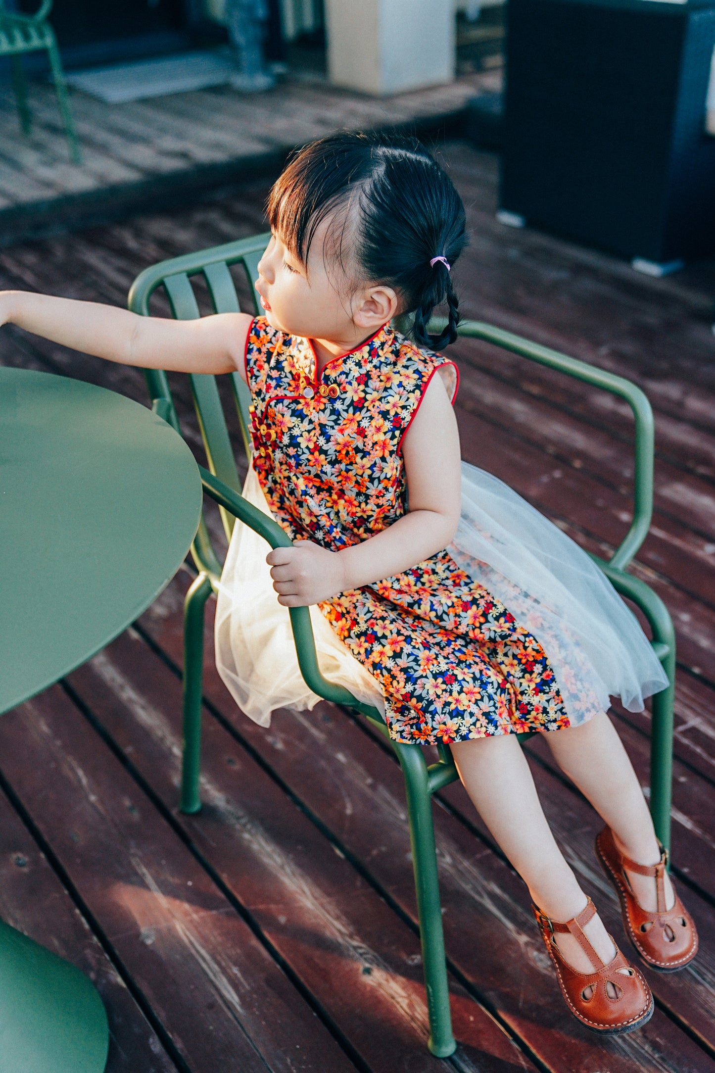 Child modeling a navy floral qipao-inspired dress outdoors