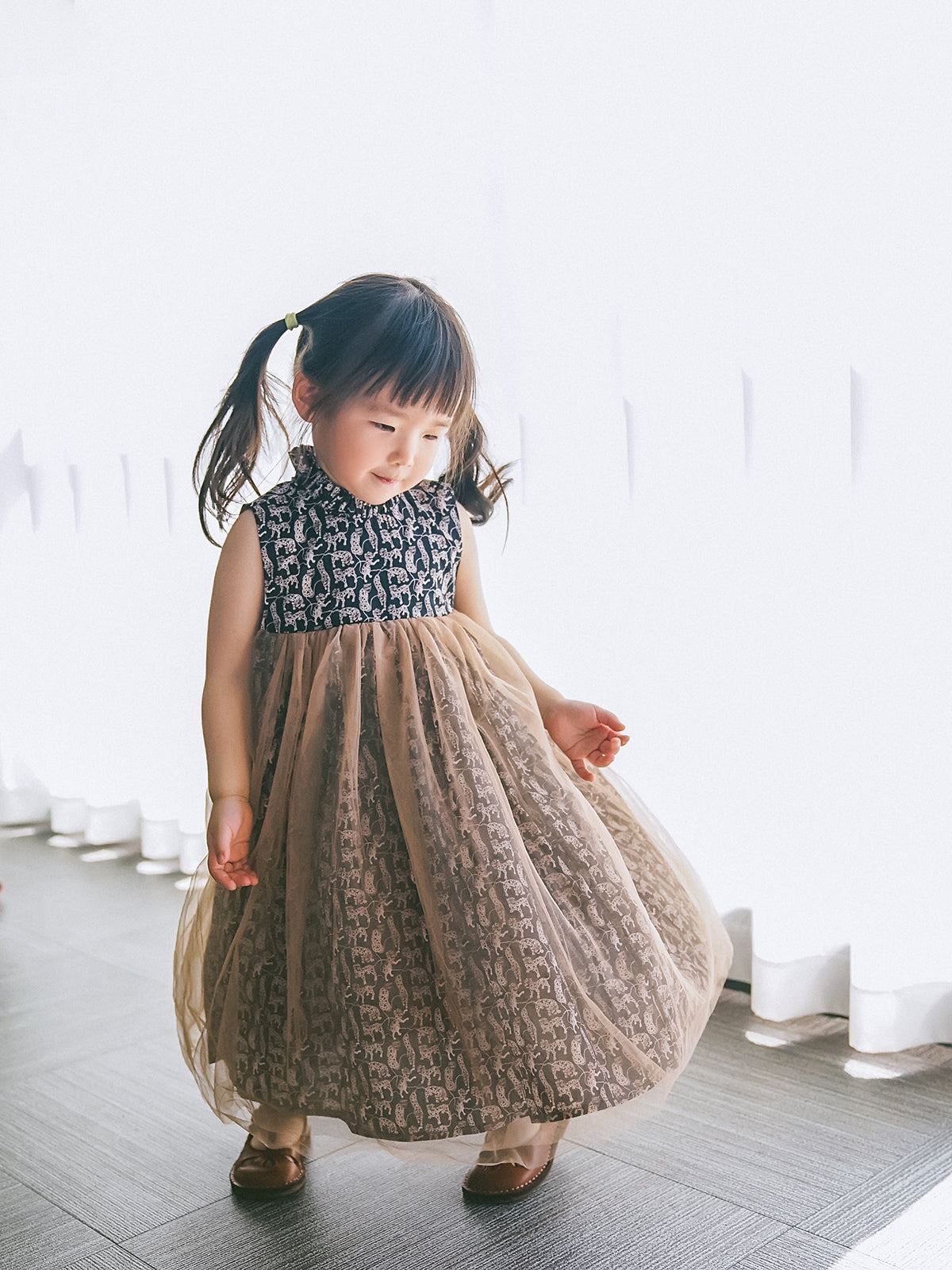 Girl wearing a black-and-white Animal Print tulle dress with a Mandarin collar