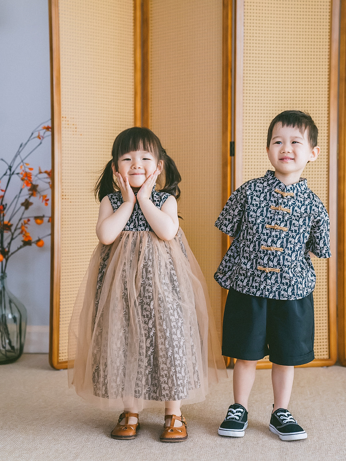 Brother and sister wearing coordinated Animal Print Chinese-inspired outfits, including the girls' tulle dress