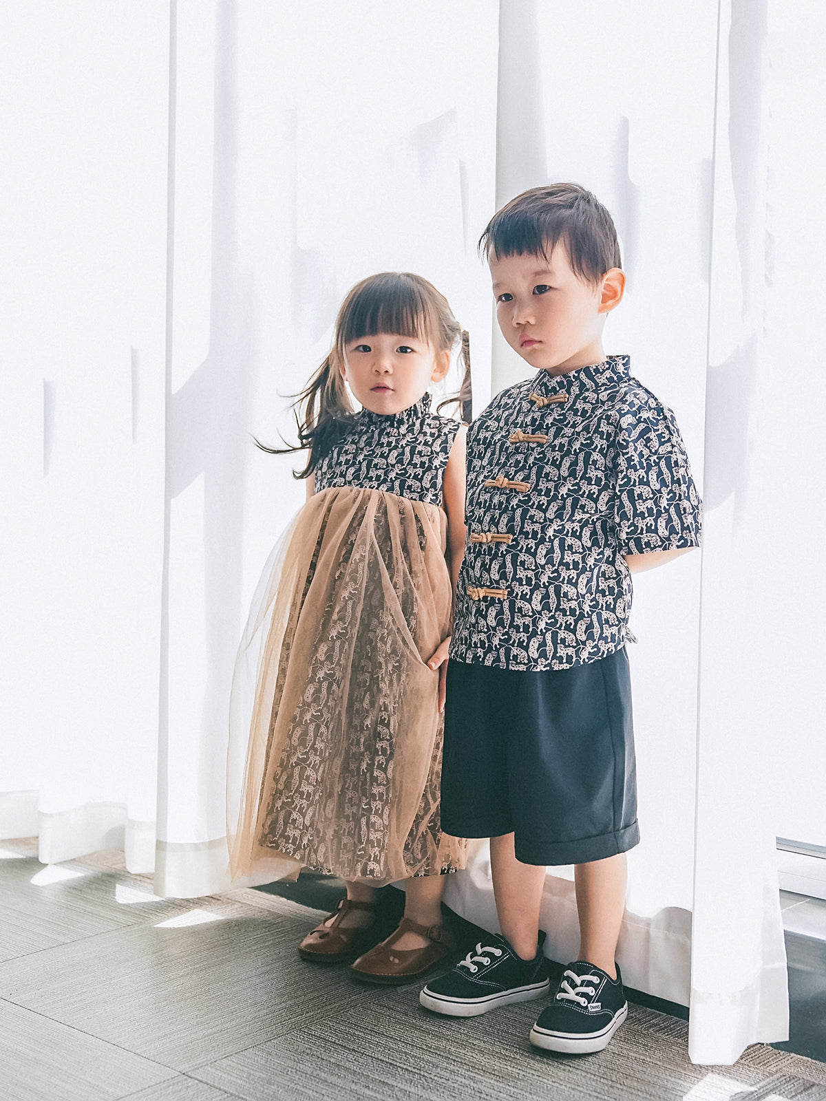 Brother and sister wearing coordinated Animal Print Chinese-inspired outfits