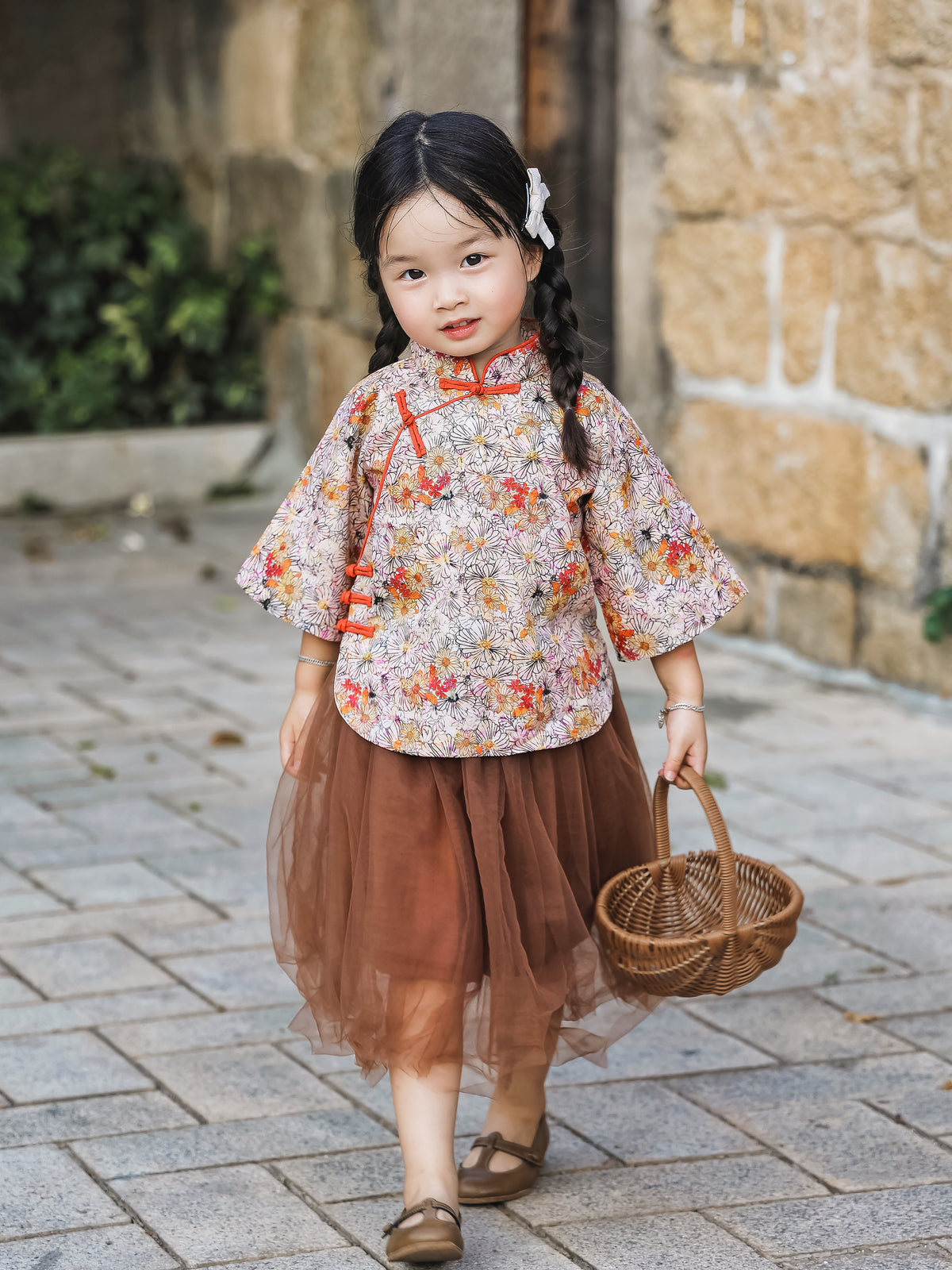 Girl wearing the floral Mandarin top and chestnut tulle skirt set outdoors