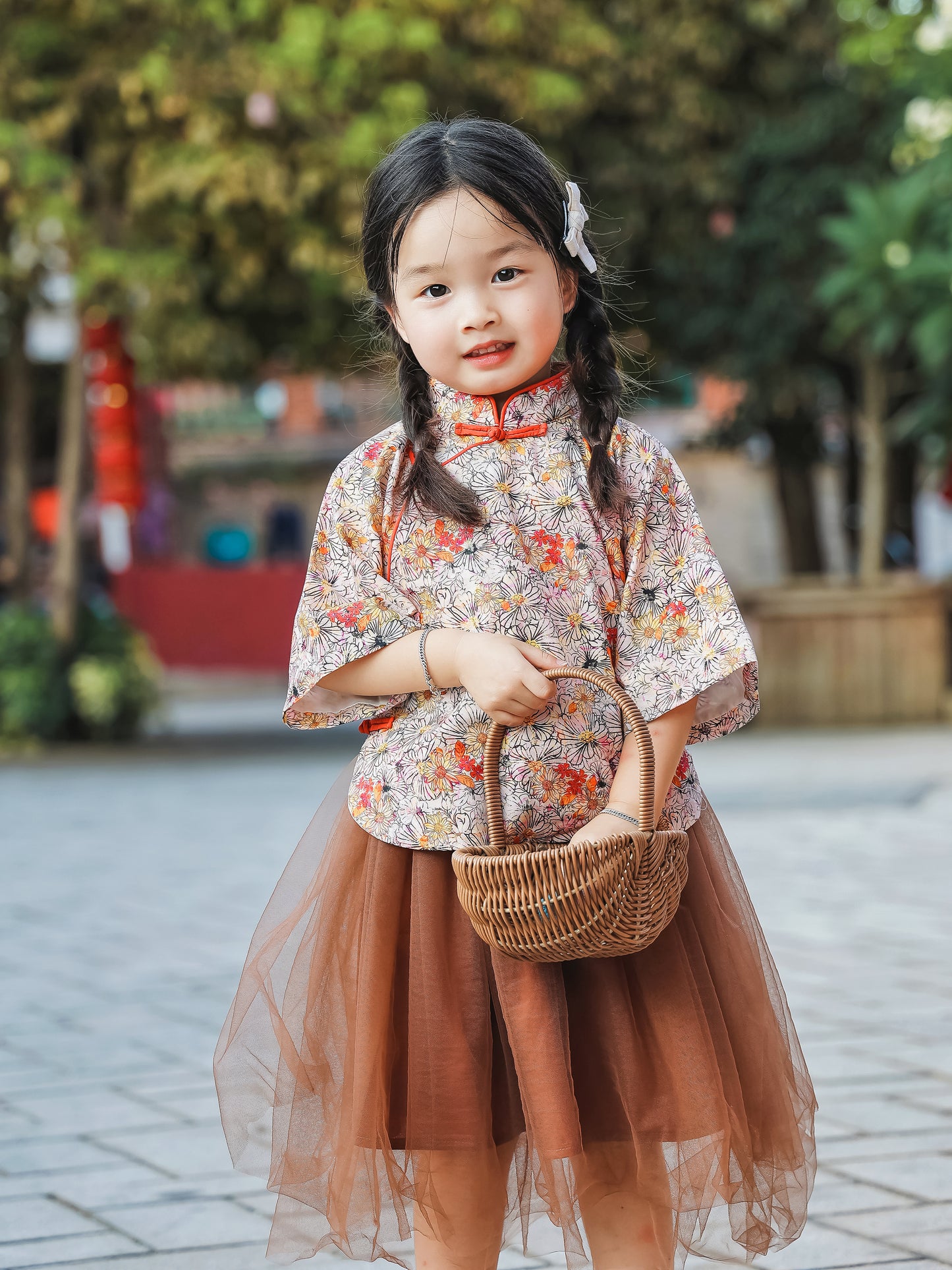 Girl wearing the floral Mandarin top and chestnut tulle skirt set with basket