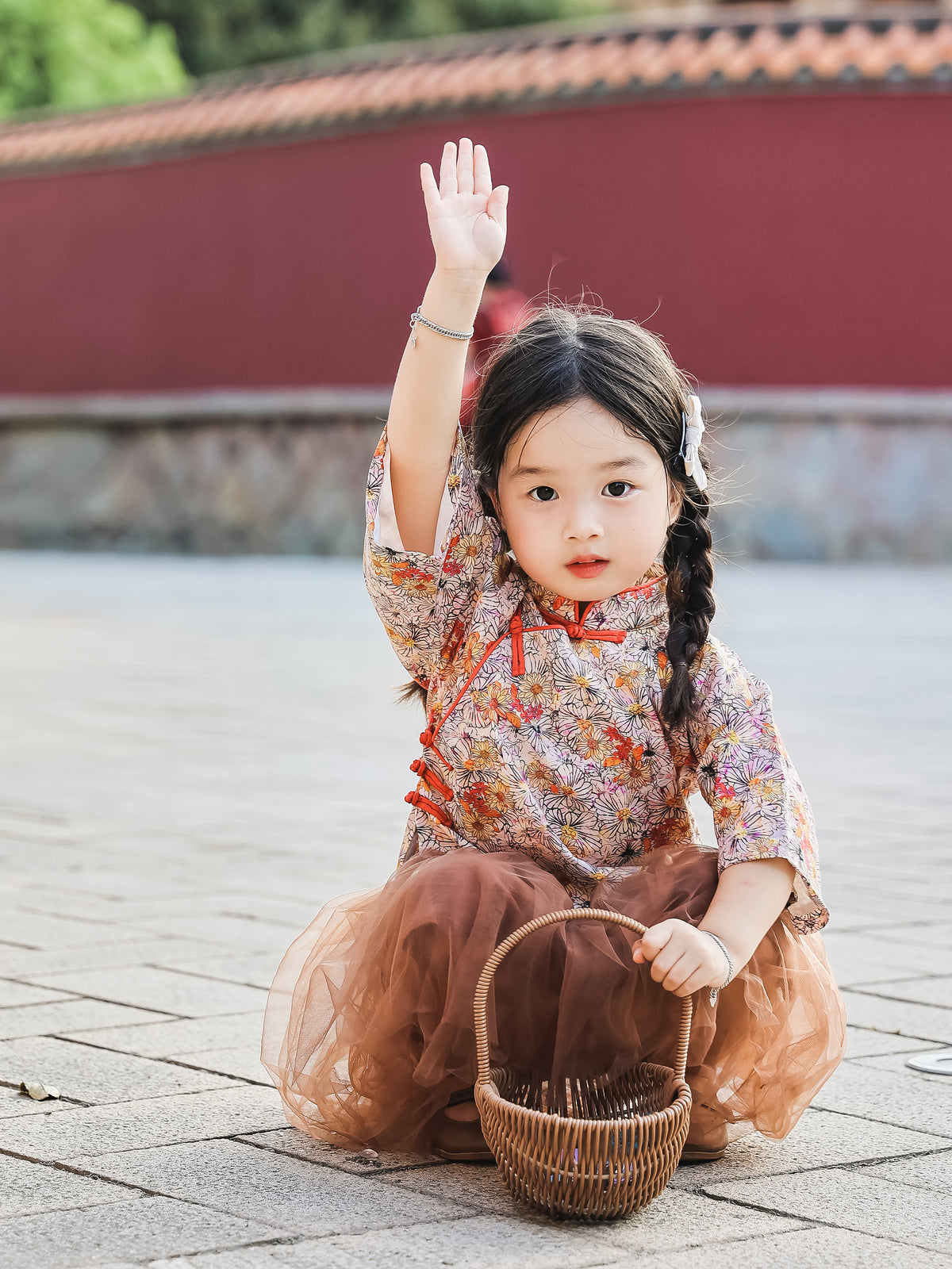Girl seated in the floral Mandarin top and chestnut tulle skirt set outdoors