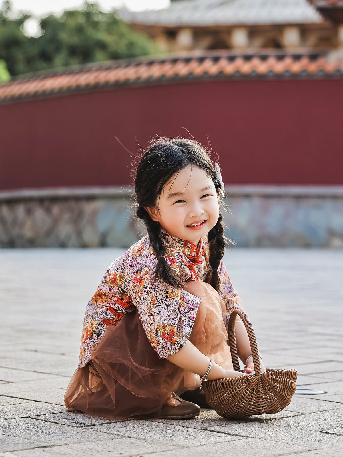 Girl seated in the floral Mandarin top and chestnut tulle skirt set