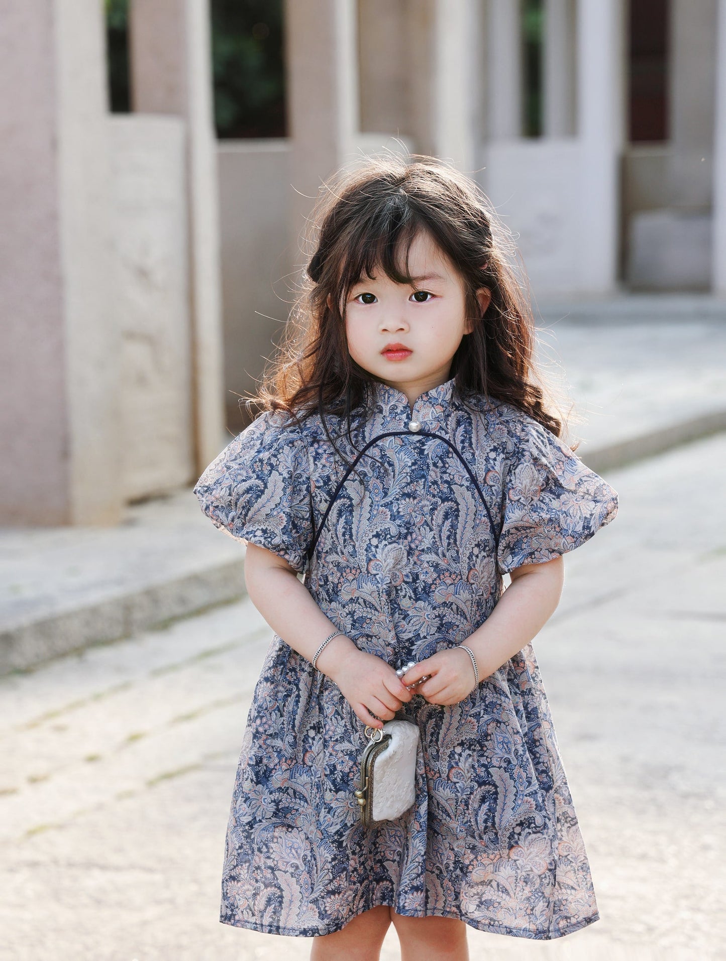 Girl wearing the Blue Paisley puff-sleeve qipao dress, front portrait