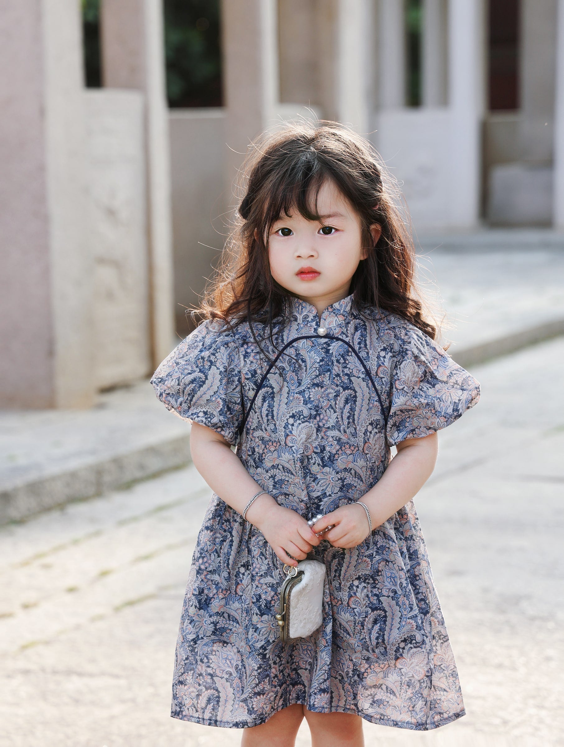 Girl wearing the Blue Paisley puff-sleeve qipao dress, front portrait