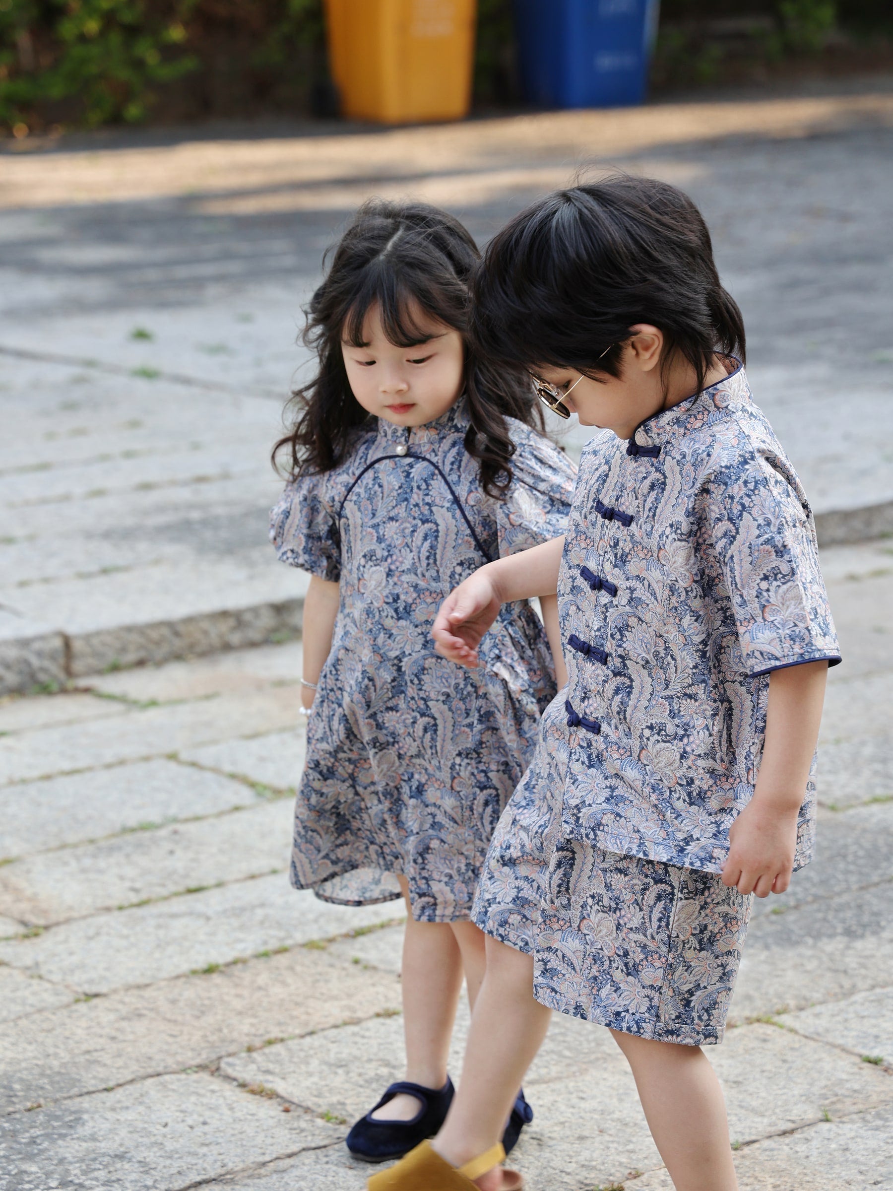 Siblings walking in coordinated Blue Paisley outfits