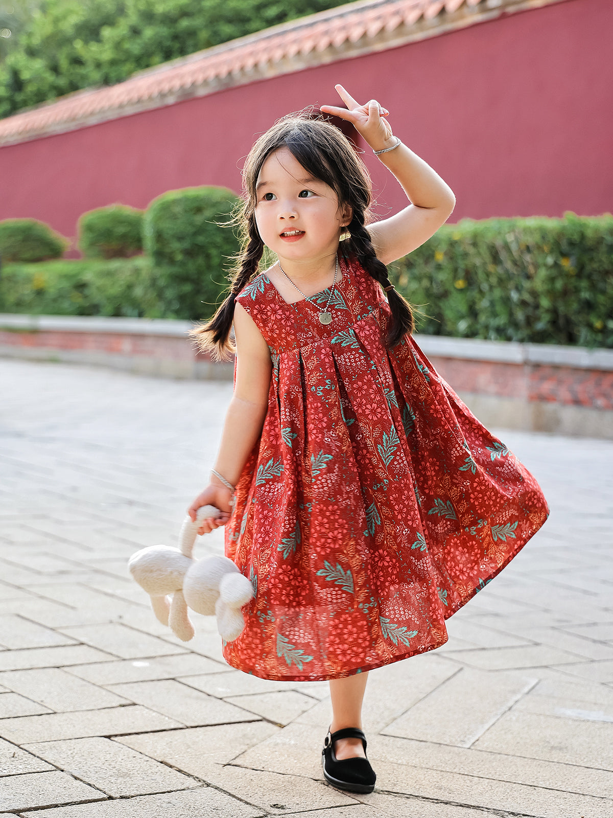 Girl twirling in Holiday Bloom red floral sleeveless dress