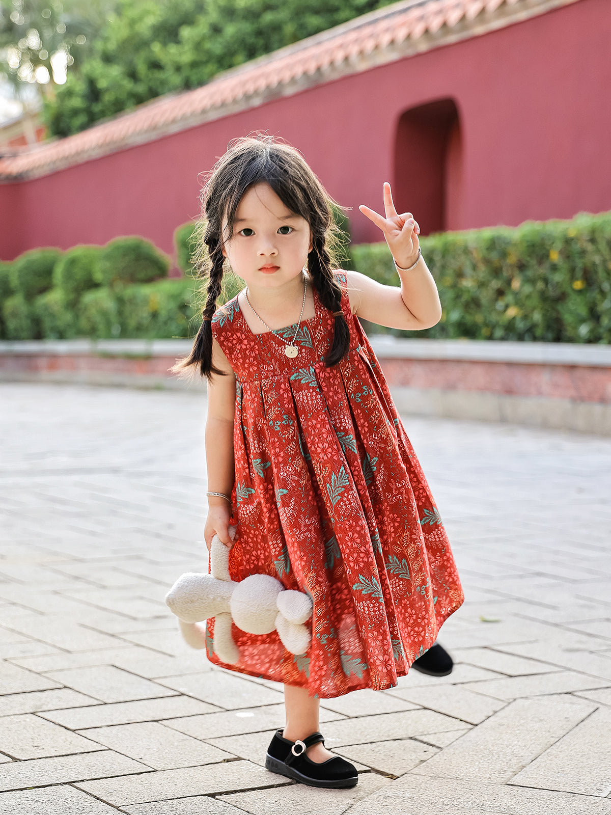 Girl wearing Holiday Bloom red floral sleeveless dress outdoors