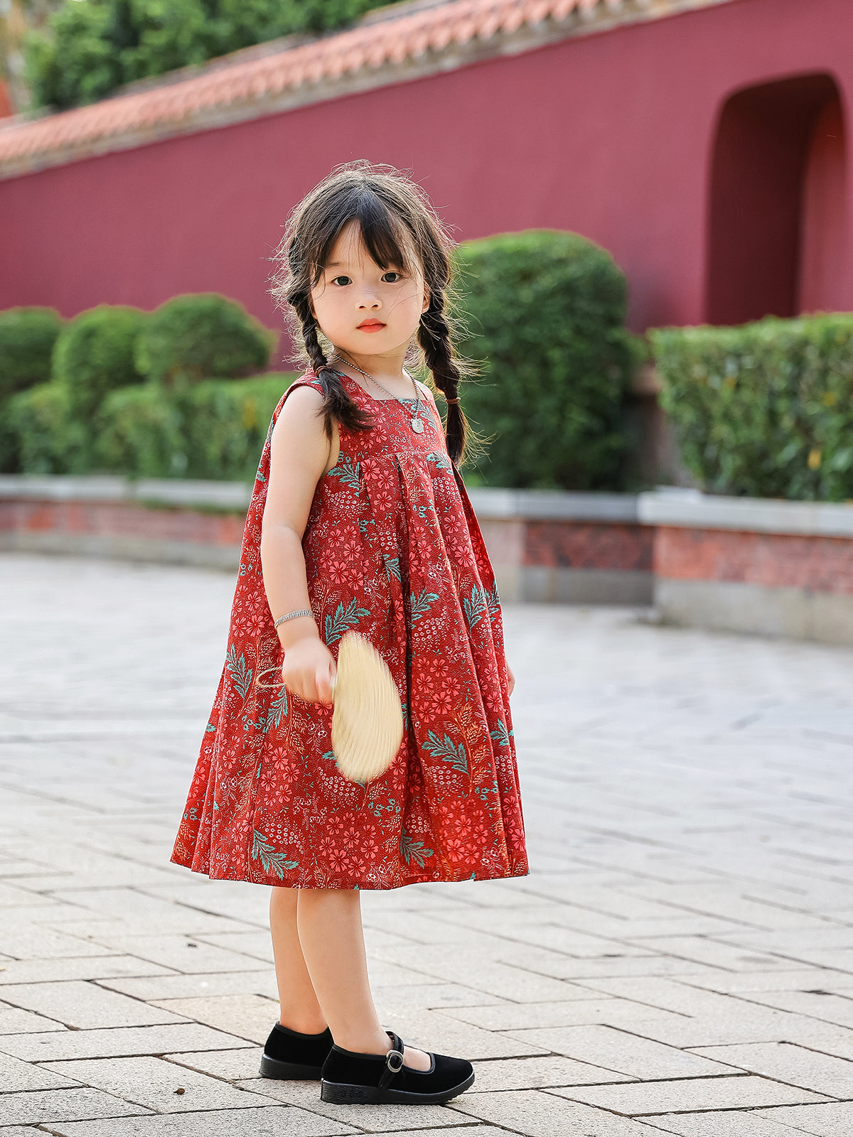 Girl standing in Holiday Bloom red floral sleeveless dress