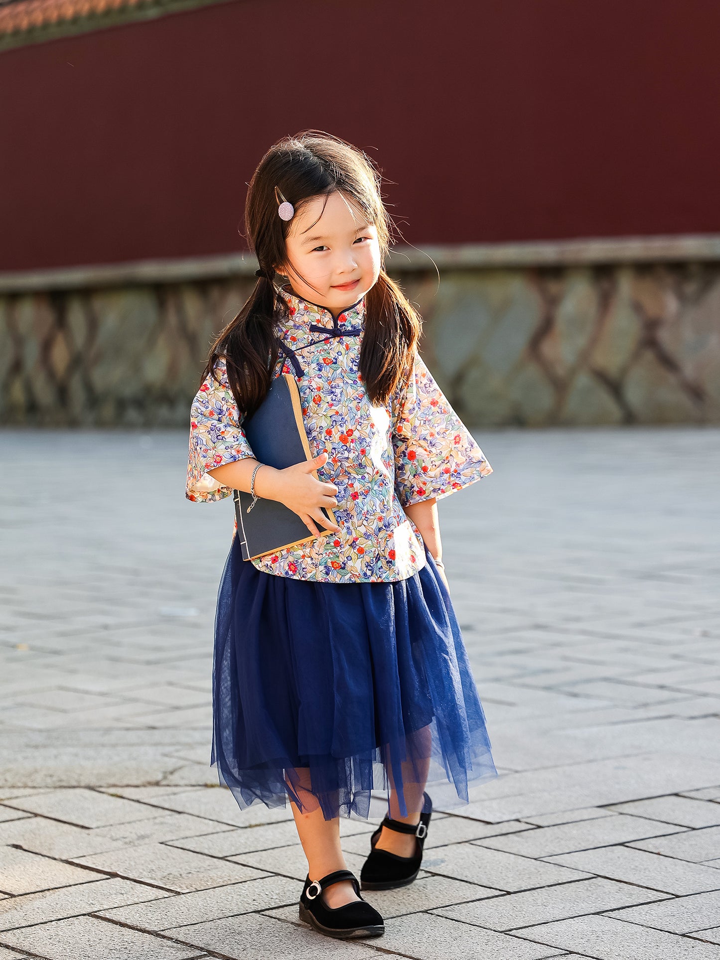 Girl wearing the Indigo Berry floral Mandarin top and navy tulle skirt set