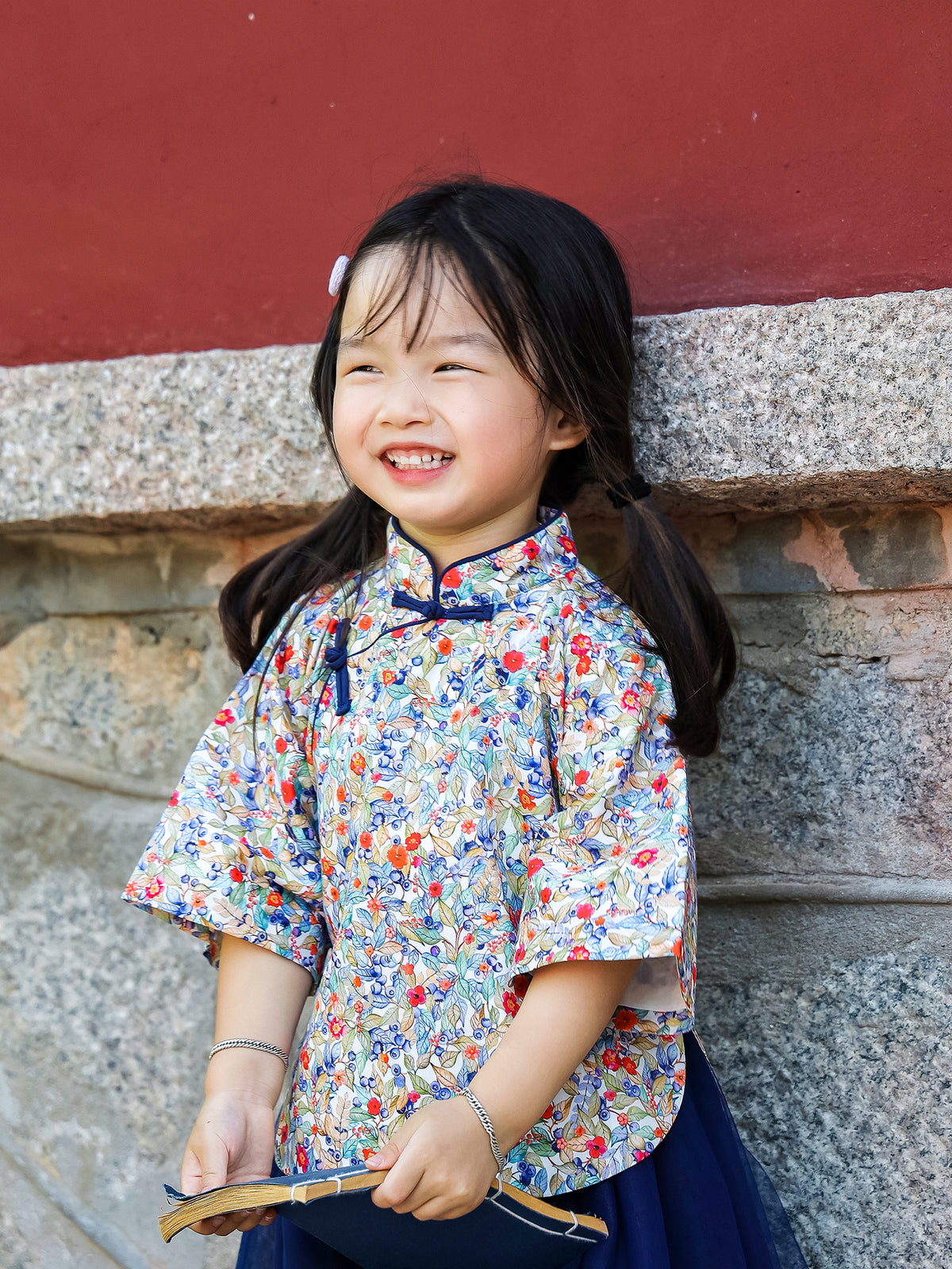 Girl smiling in the Indigo Berry floral Mandarin top and navy tulle skirt set