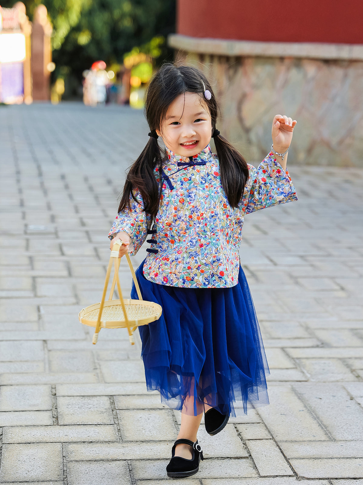 Girl carrying a basket in the Indigo Berry floral Mandarin top and navy tulle skirt set
