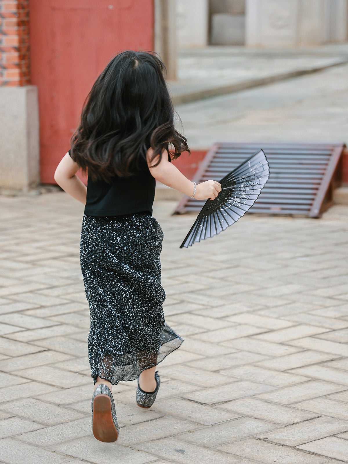 Girl wearing the Little Cloud Mandarin collar tee in Deep Black, back view