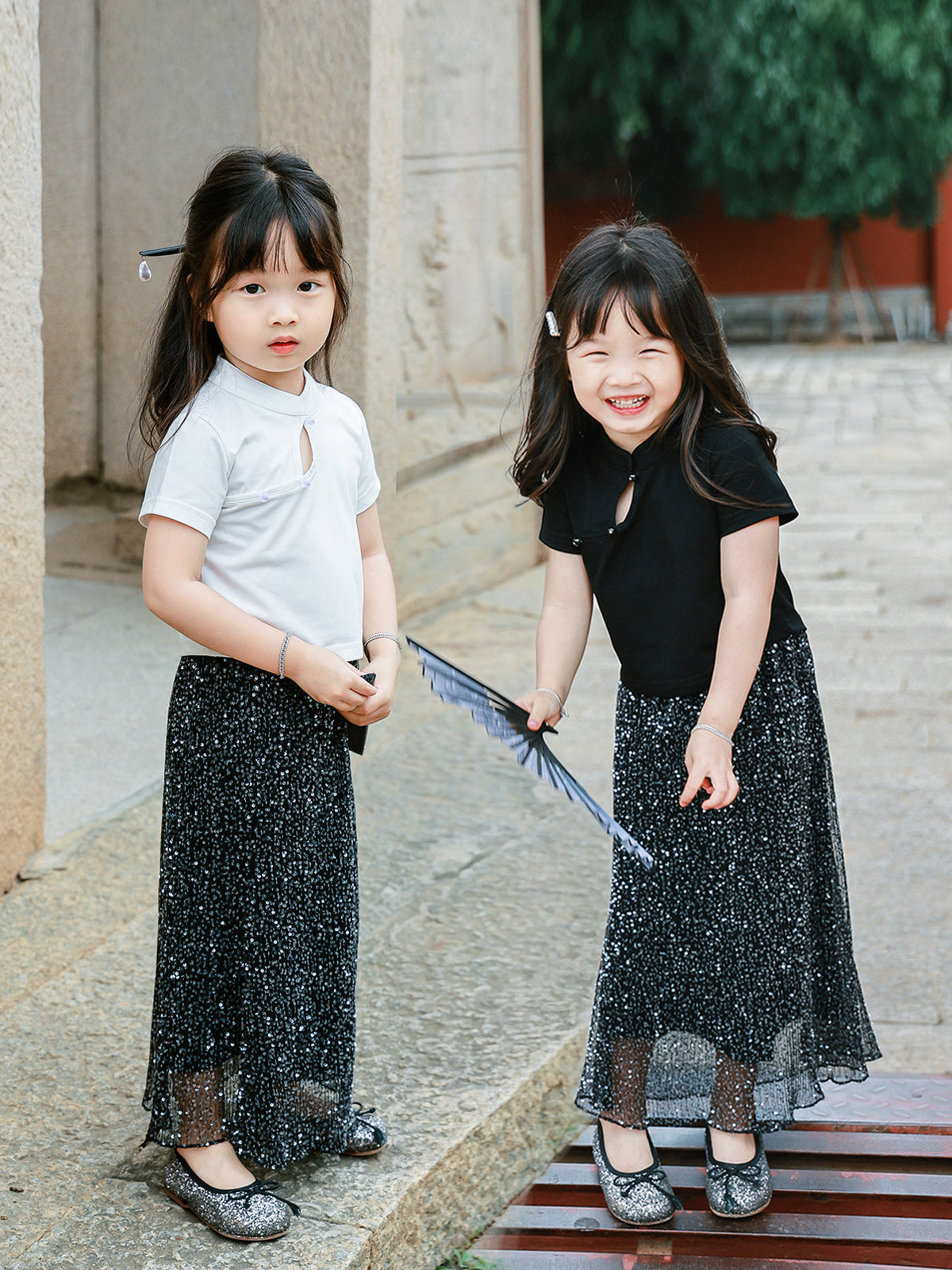 Two girls wearing the MOETOMOMI Little Cloud Mandarin collar keyhole tee in Pure White and Deep Black