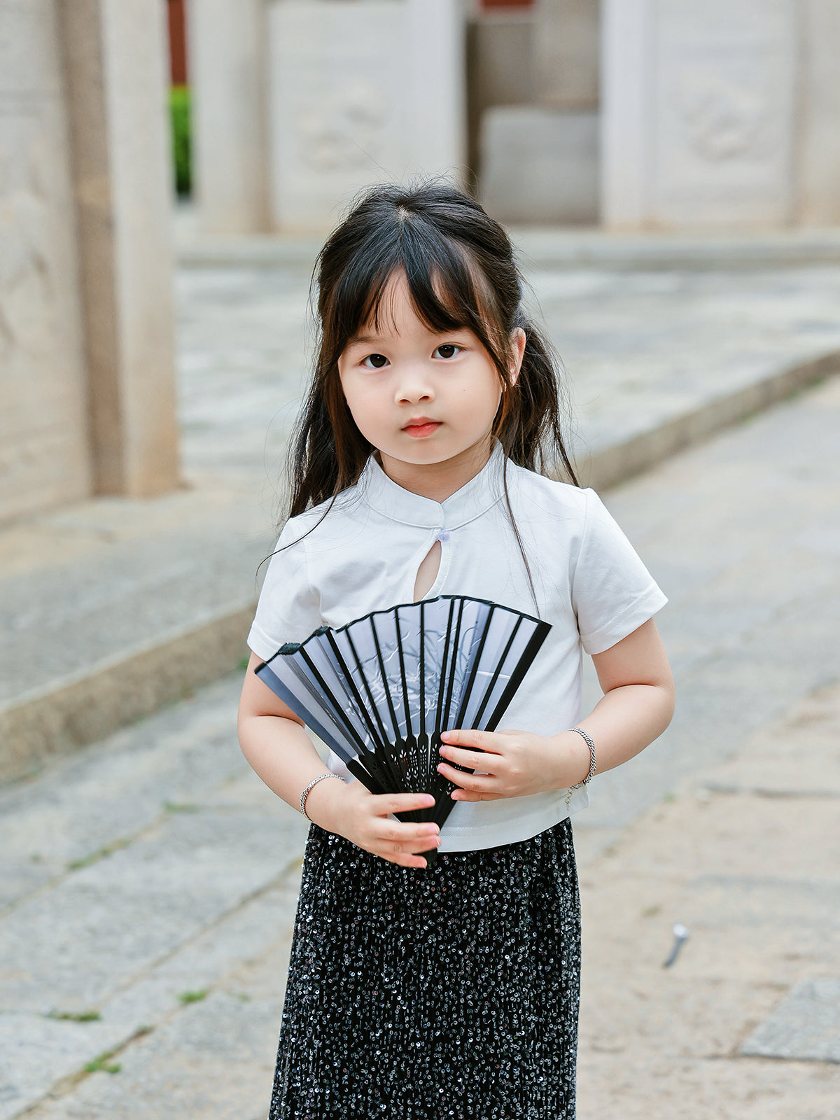 Girl wearing the Little Cloud Mandarin collar tee in Pure White, front view with fan