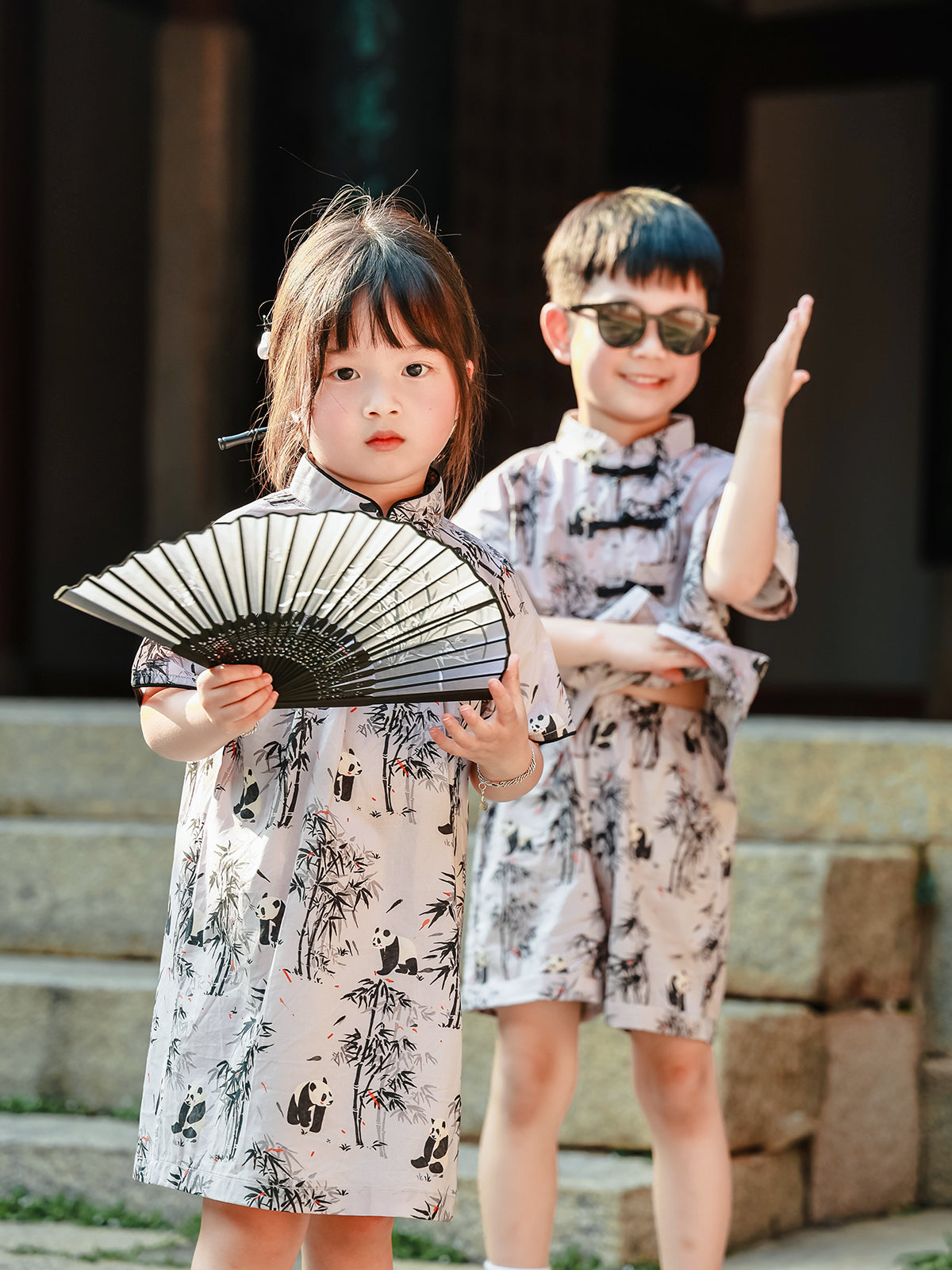 Sibling matching Panda Bamboo outfits with fan