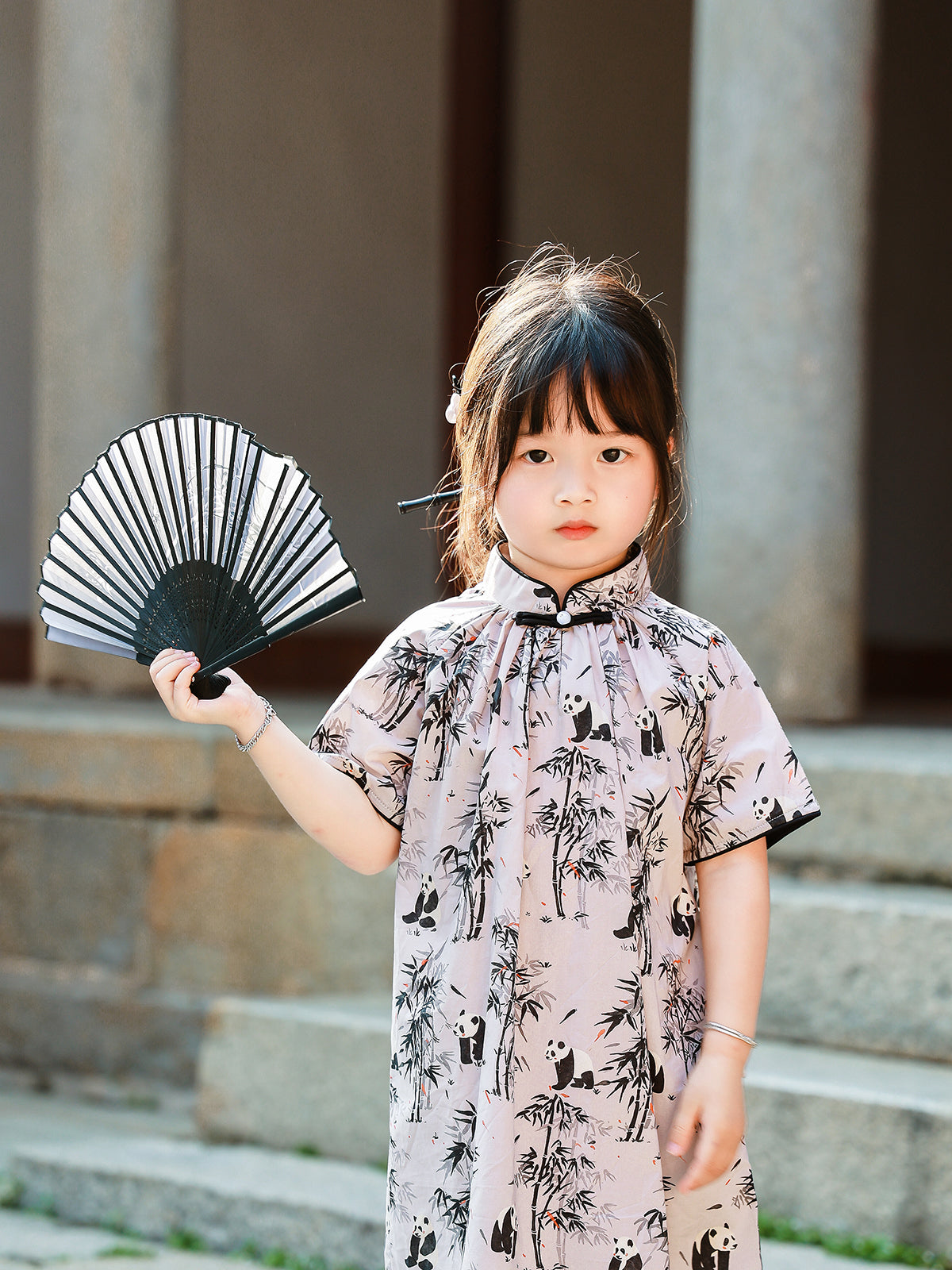 Girl wearing Panda Bamboo qipao dress with fan
