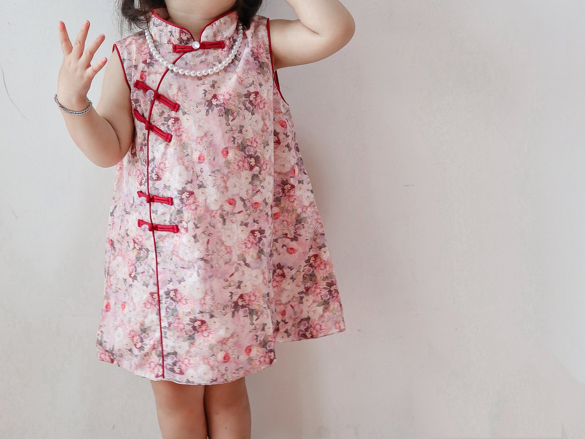 Close view of the pink floral qipao dress in a warm home setting